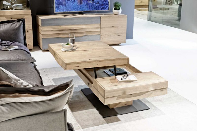 Table de salon amovible avec différents étages ouverte haut de gamme en chêne disposée dans une pièce moderne avec des canapés en textile design allemand